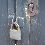 An old building or trailer with an old padlock locked on the doors creating privacy.