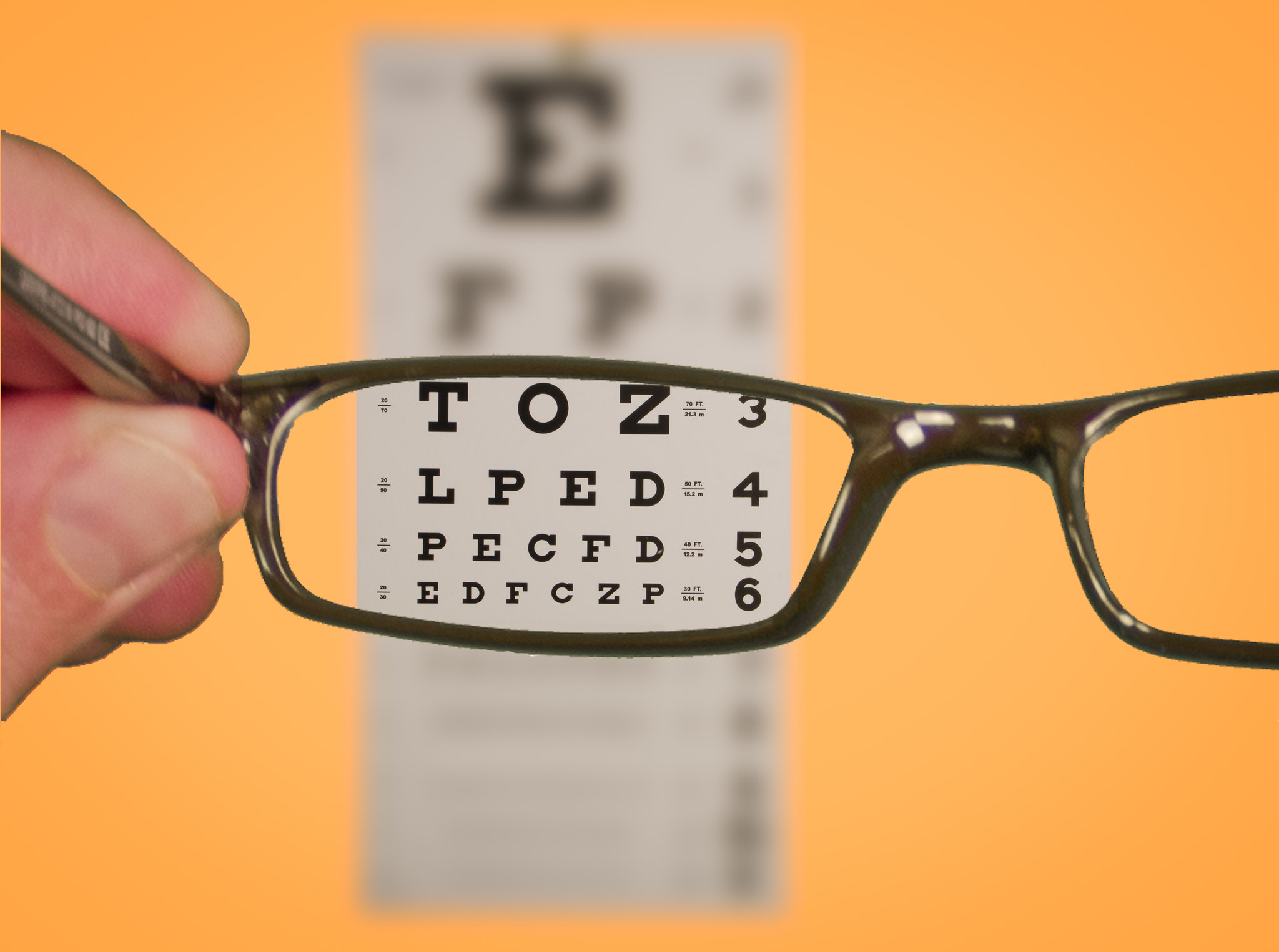 Showing visual rhetoric through an eye glass looking at a vision chart.