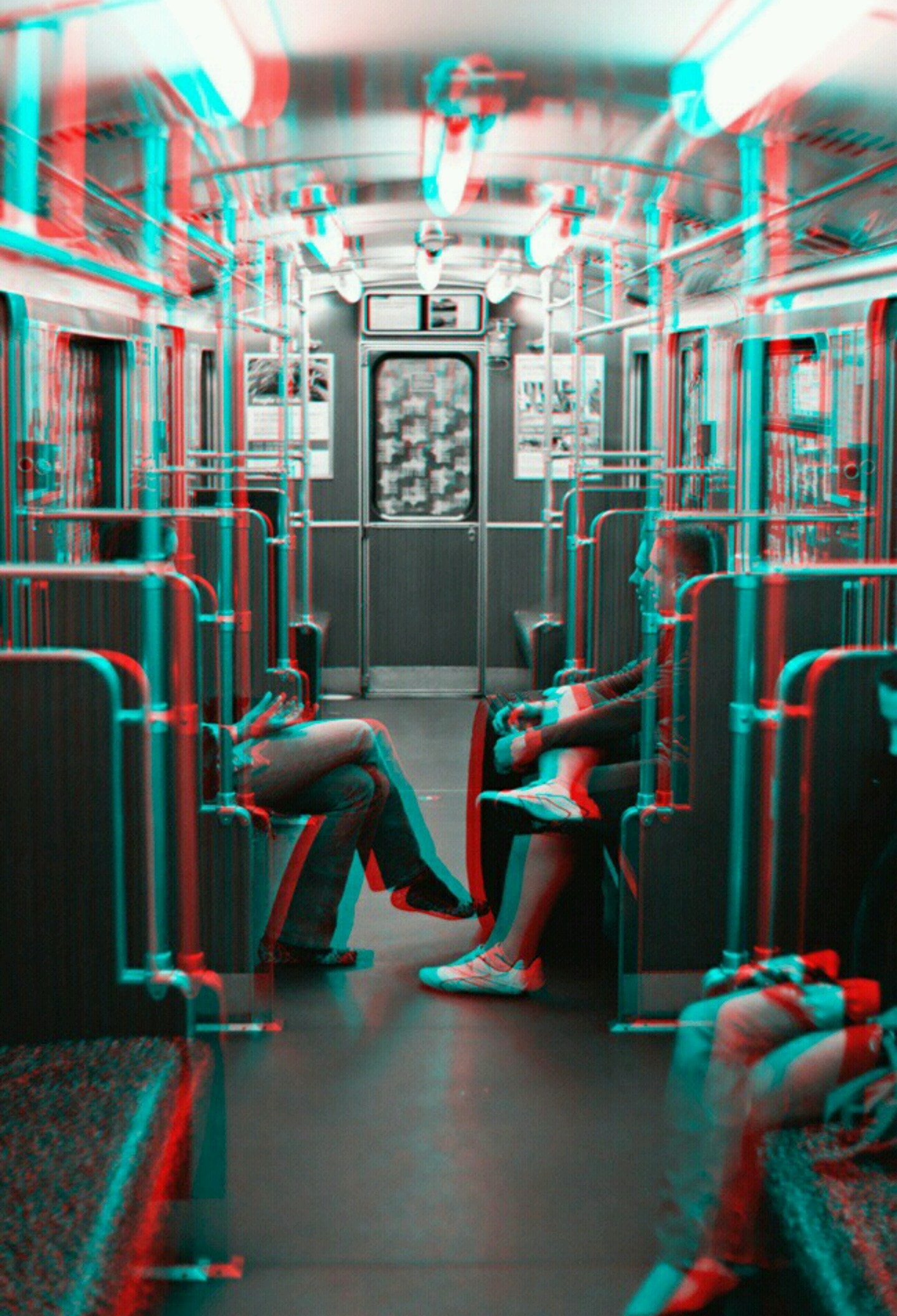 A black and white photo of the interior of a subway car. Two people's legs rest in the middle, facing each other. There is red and blue chromatic aberration overlayed on top of the image.