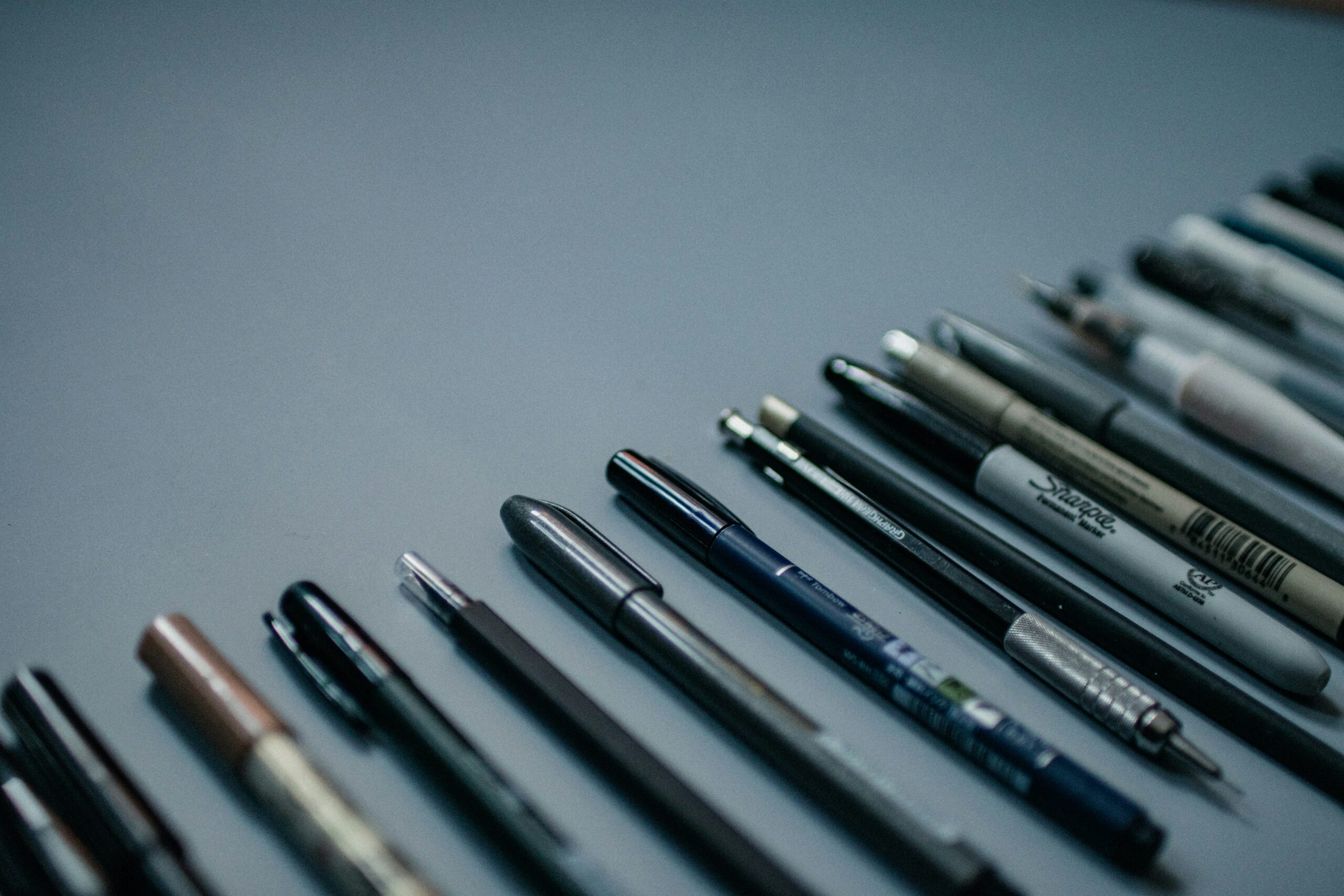 image of various writing utensils in a line.