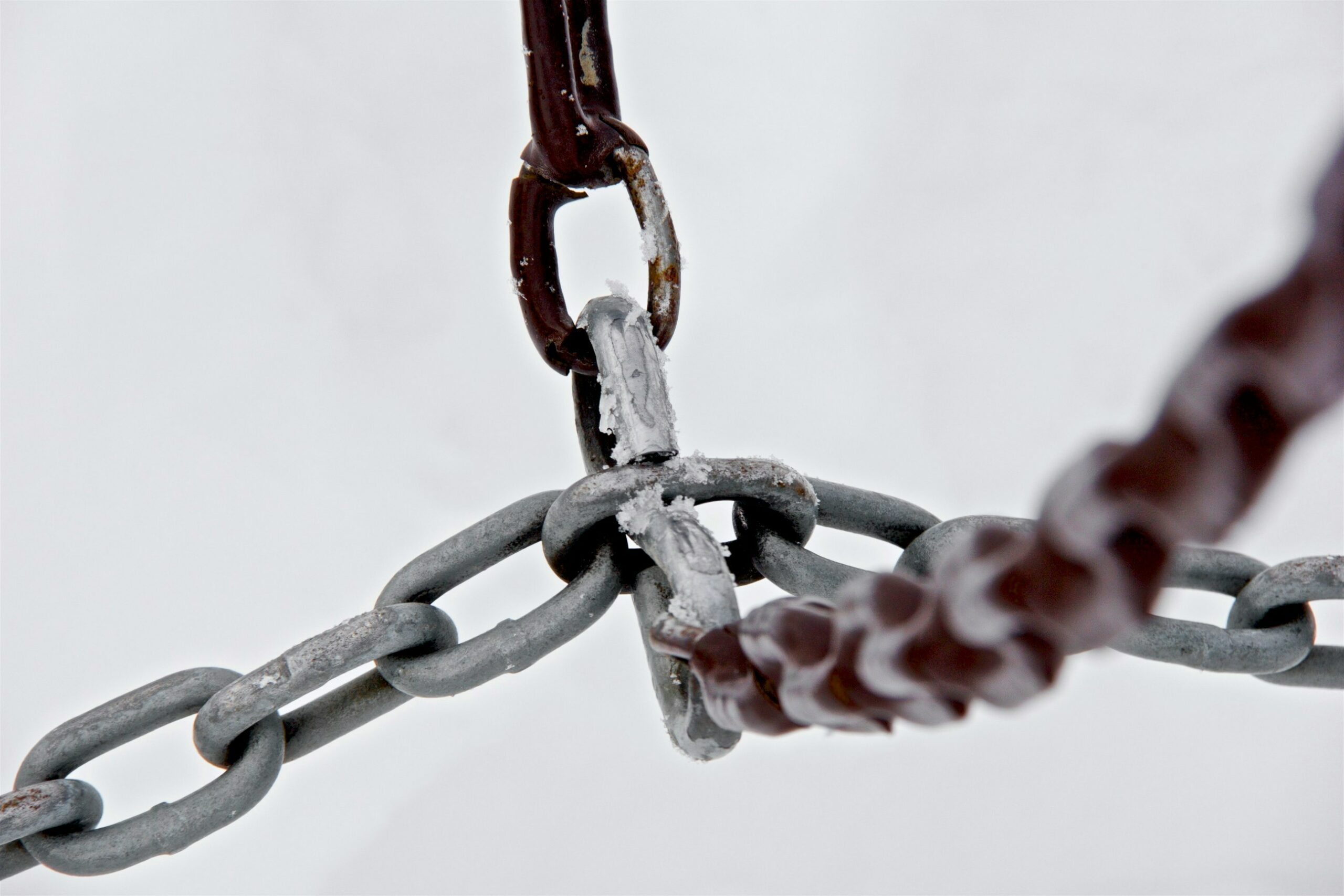 The photo depicts four gray metal chains connecting to each other.