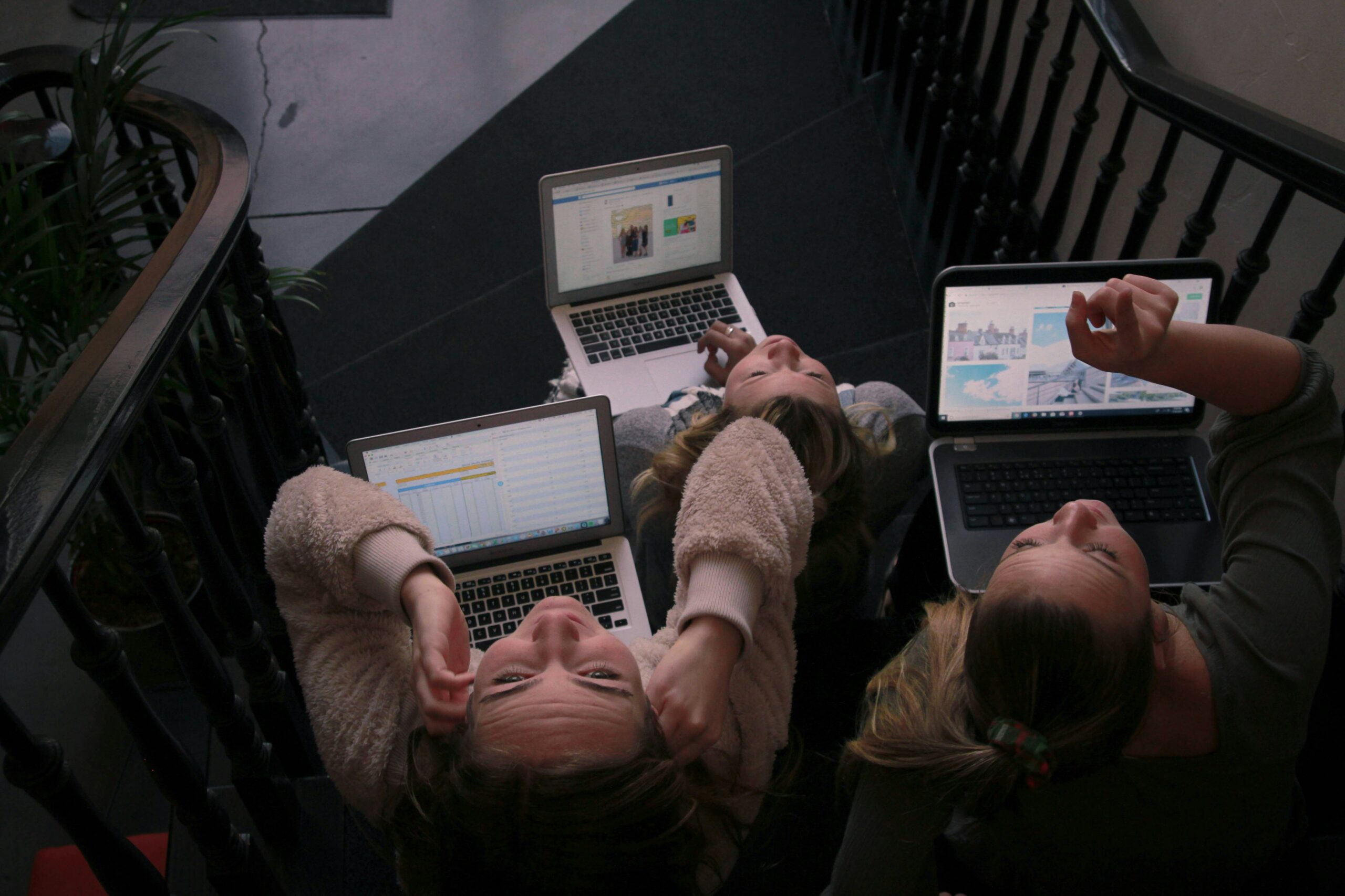 It is an image of three young females who are doing their own work while being outside. All of them are looking up, but one of them is holding head as if they're stressed out. Kind of like how it feels like trying to interpret Eyman's interpretation of digital literacy.