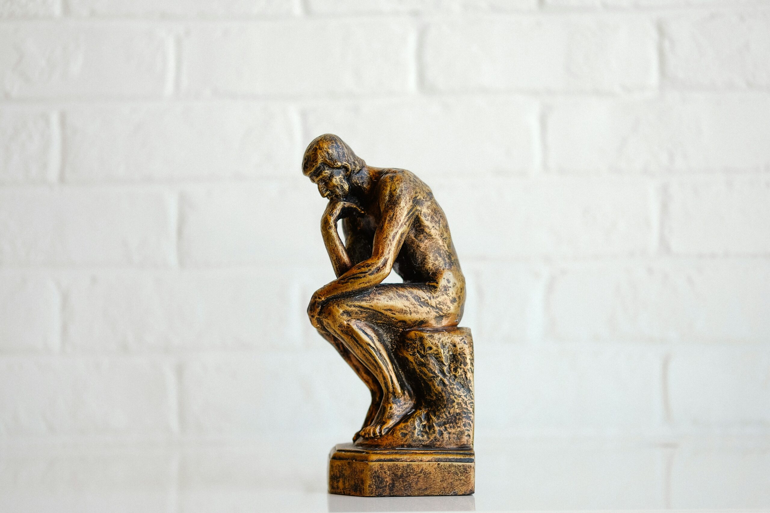 bronze figurine doing the famous "thinking pose"