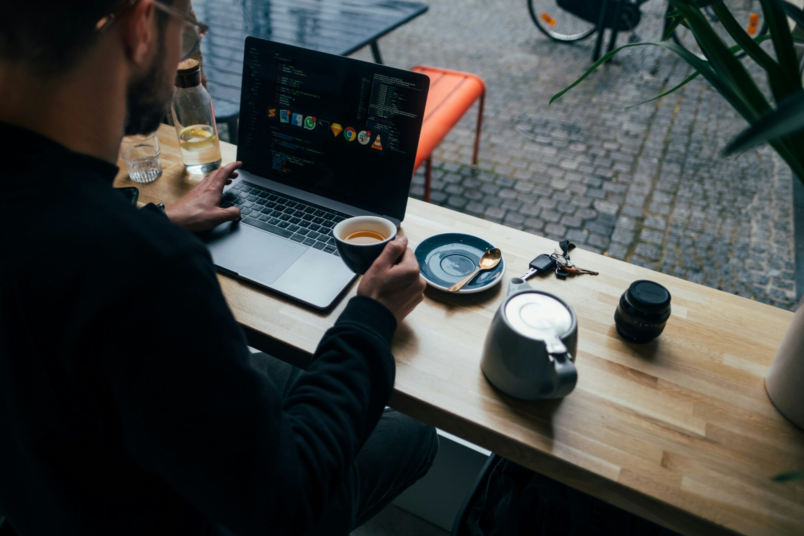person typing on laptop while drinking coffee