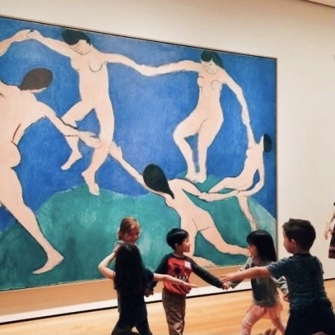 Children posing in a circle, referencing the painting beside them.