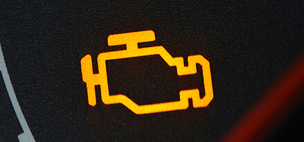 A typical check engine light, with a yellow image of an engine against a black background.