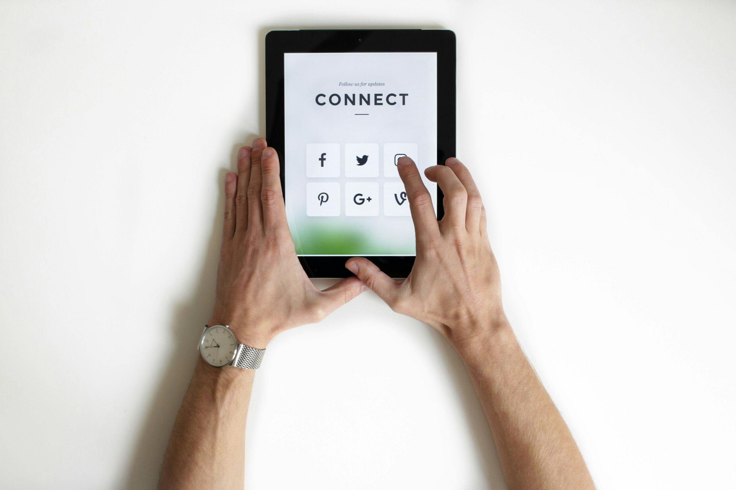 Person's hands touching a digital tablet.