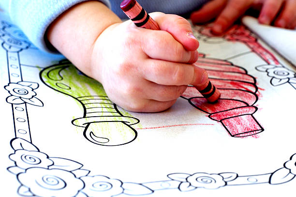 Little kid hands color in an interactive book.