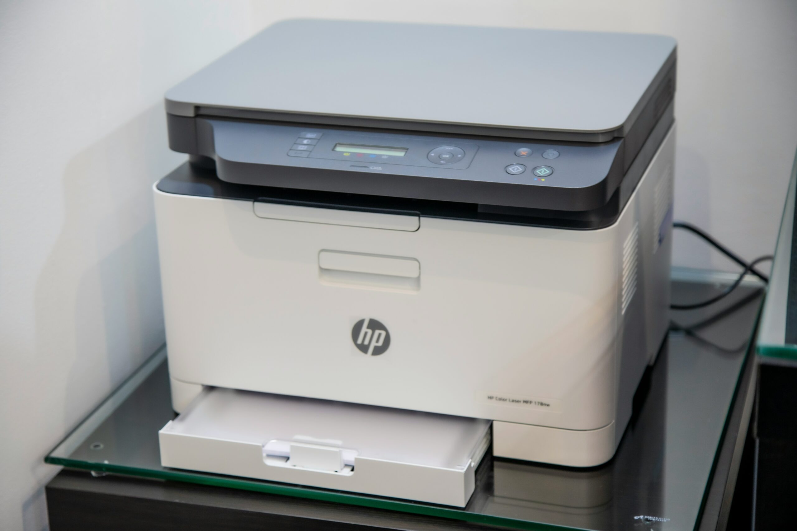 An HP Printer about to print a piece of paper.
