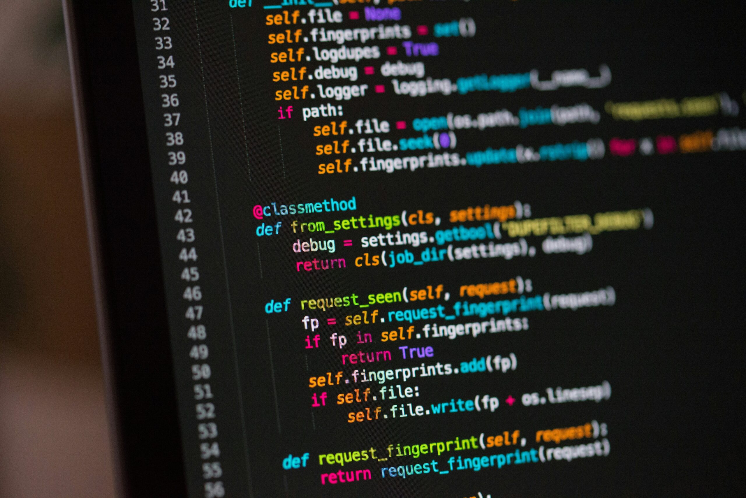 An image of lines of code being displaced on a cropped out monitor. Low level languages, like code, is influenced by the rhetoric of high level languages, or languages used by humans, such as English, Mandarin, Spanish, etc.