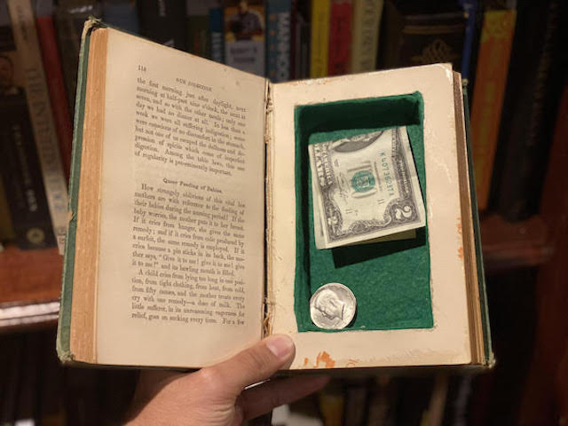 Some money is hidden inside of a hollowed out book, in the same way that information is hidden in code behind a platform.