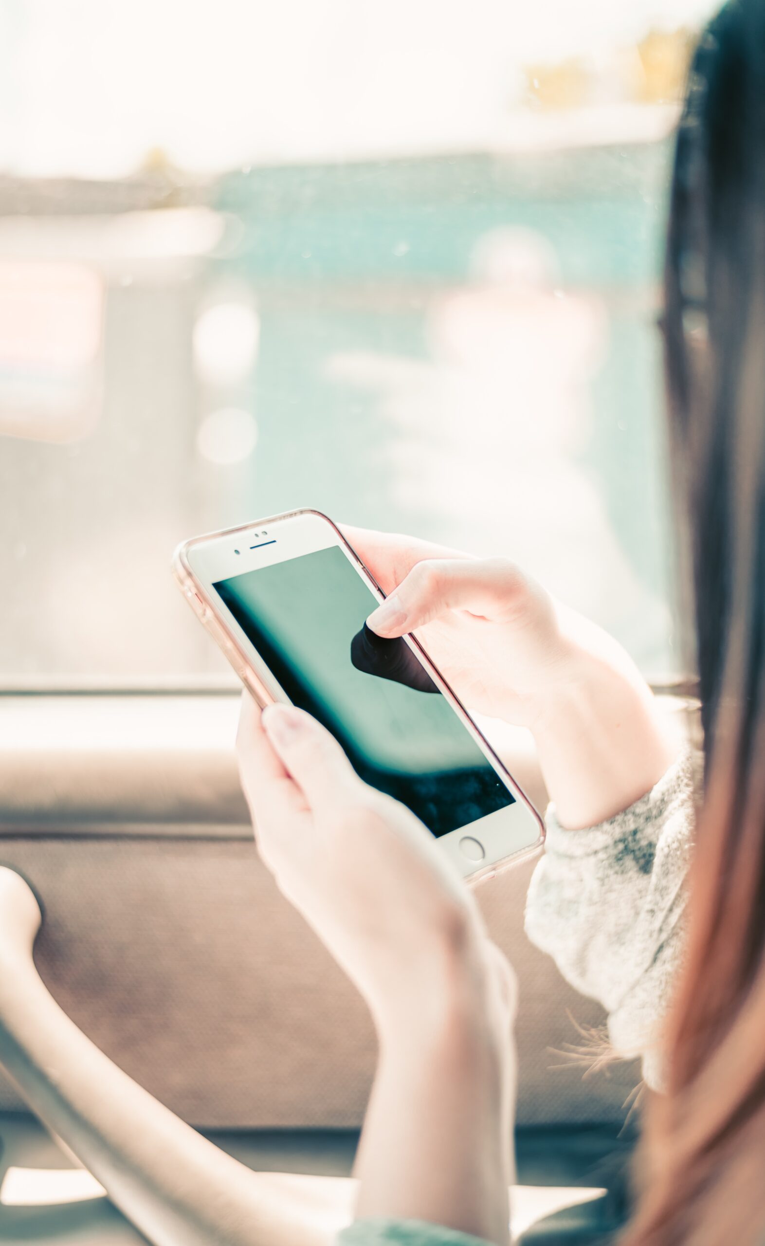 A teenage girl sitting at a desk, focused on her smartphone, representing the importance of online digital personal privacy while using networked technologies.