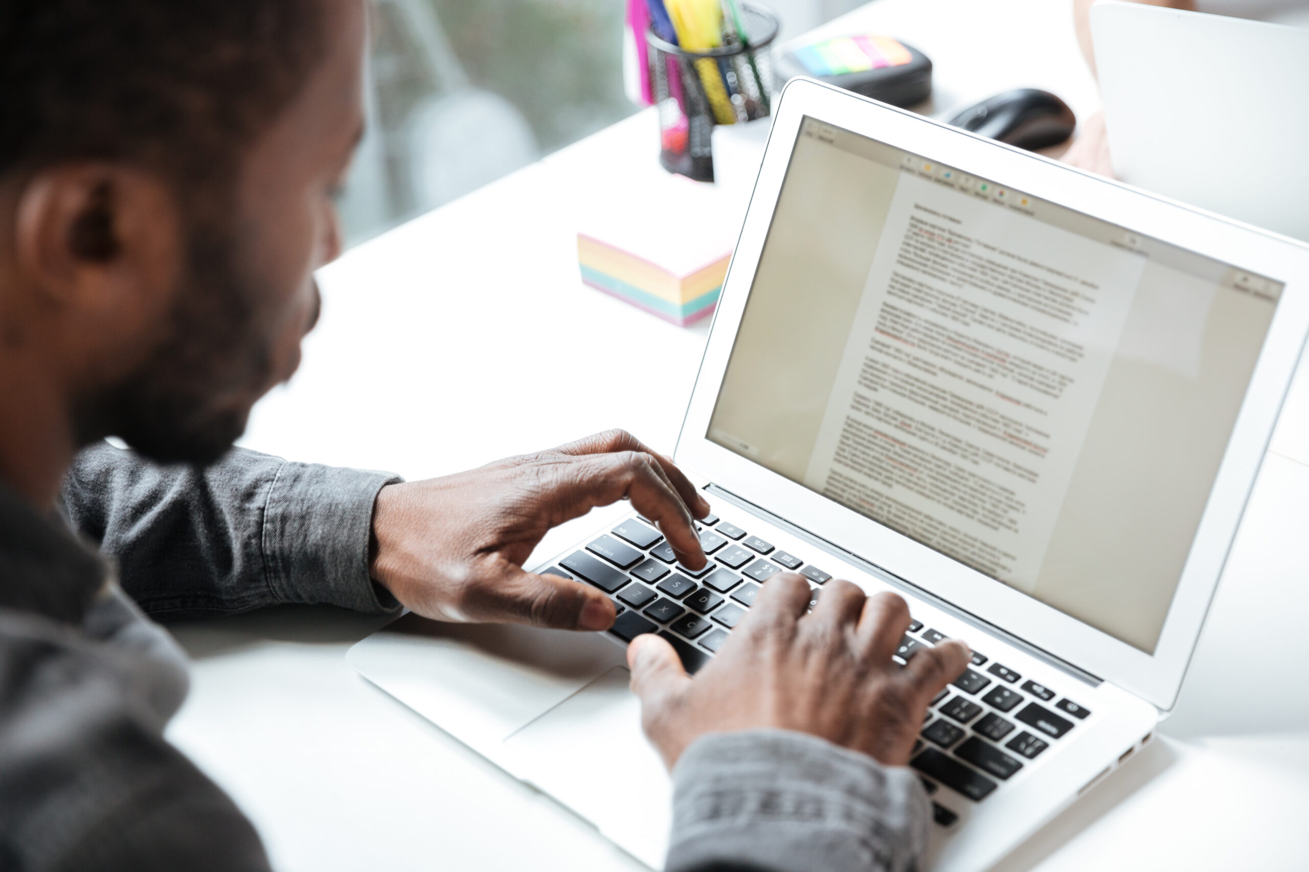 Person typing on a computer at a desk with focus on the screen.