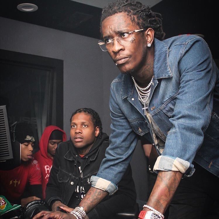 Young Thug helping someone on a laptop.