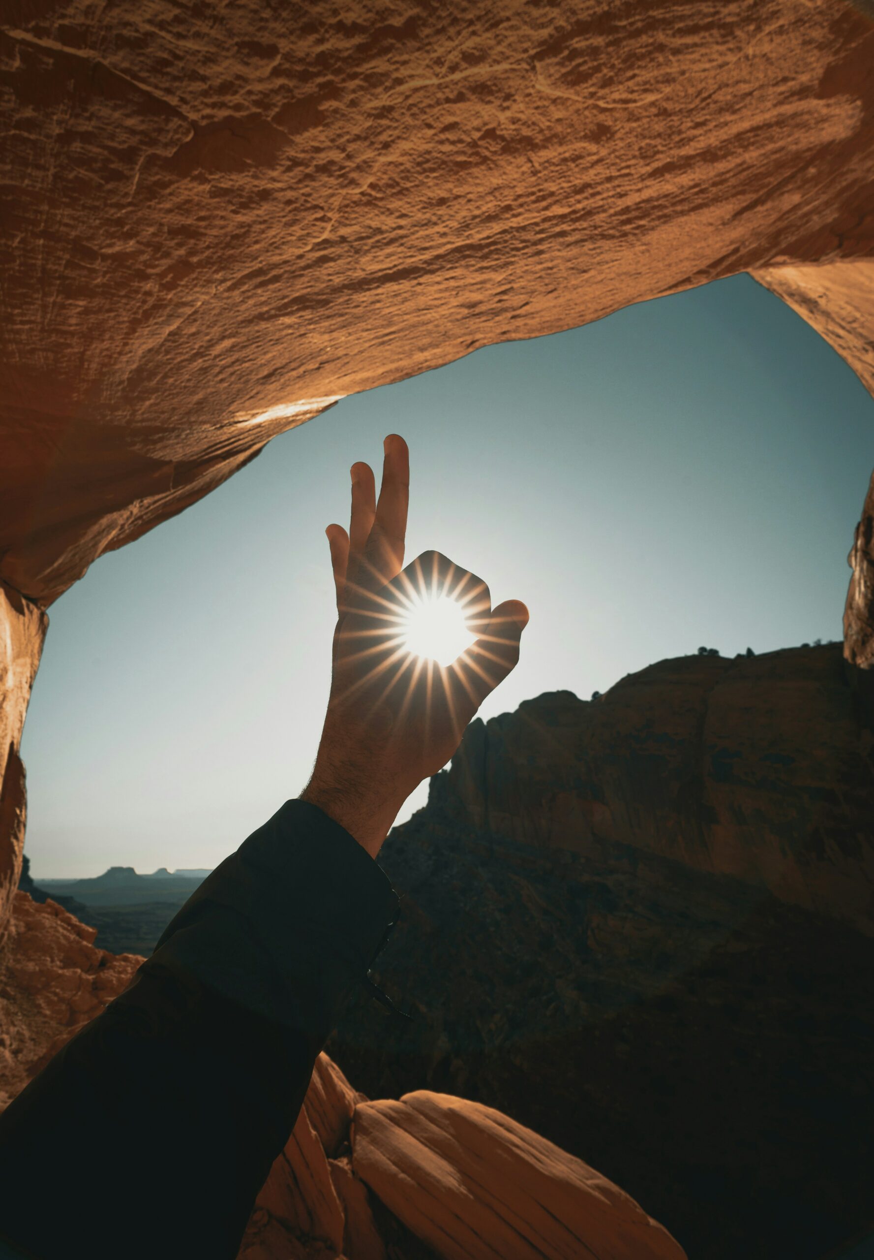The image shows a hand displaying the "ok" sign over a picture-esque scene.