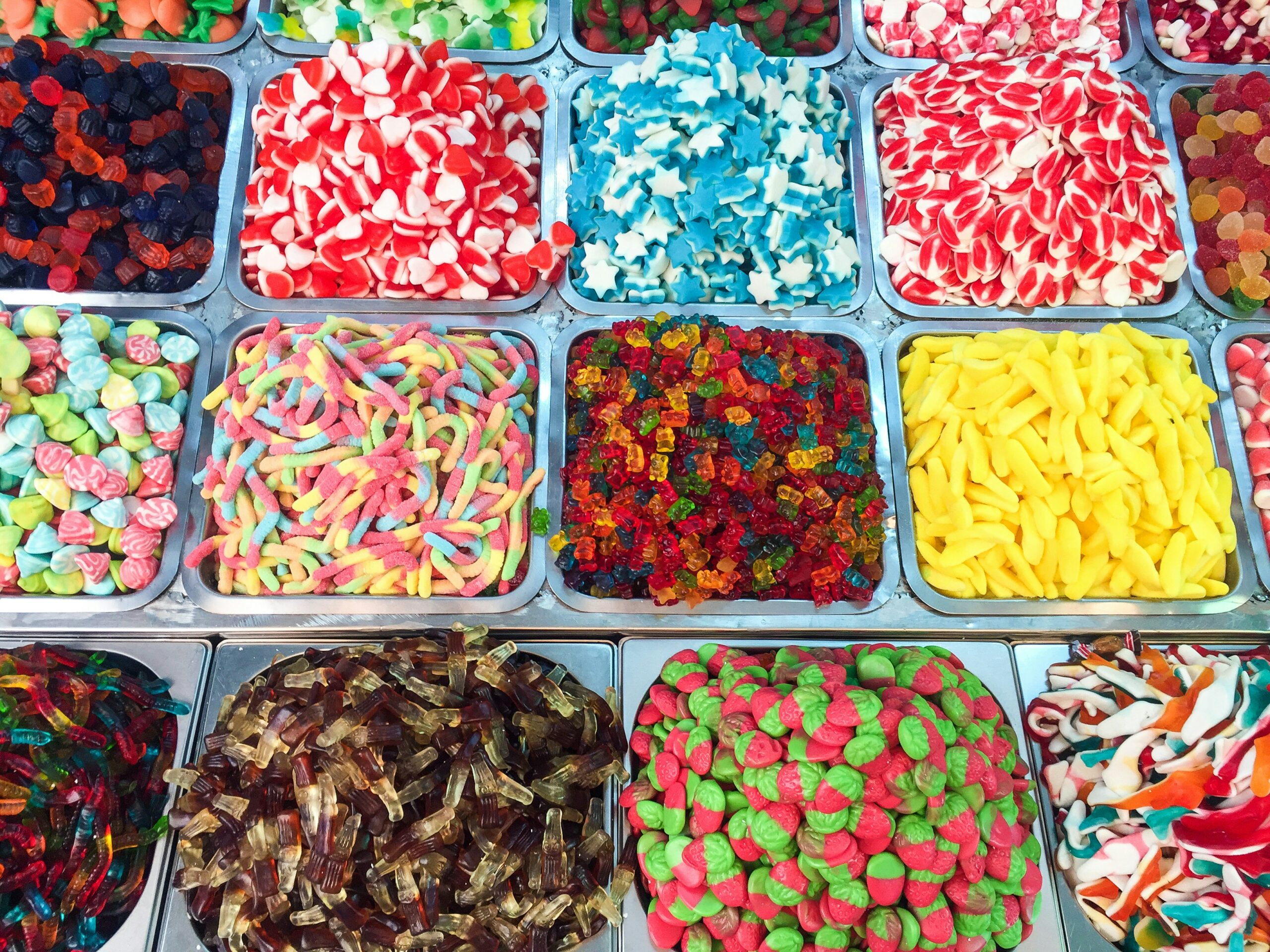 A photograph of a variety of candies being displayed in food trays.
